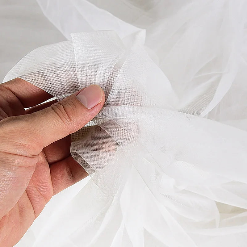 Le tissu en tulle à mailles fines micro-élastiques haute résistance de 160 cm de large est utilisé pour coudre les dessous de robes de soirée et de robes de mariée.